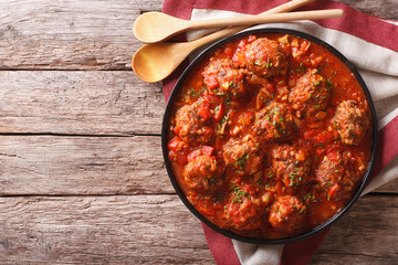 Meatballs with spicy tomato sauce on a plate on the table. horizontal top view
