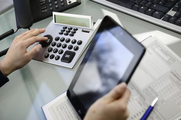 Frau kalkuliert mit Taschenrechner Umsatzsteuer