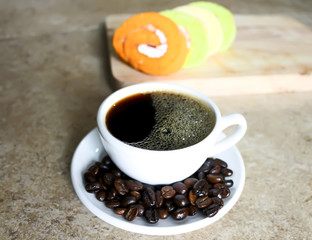 soft focus in  black coffee in White cup with 
blur cake Roll background