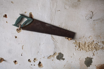 Old rustle saw on the wall