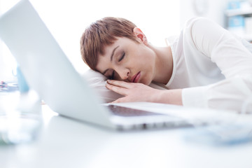 Tired businesswoman sleeping on her desk