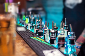 Many bottles with alcoholic beverages on the bar counter 