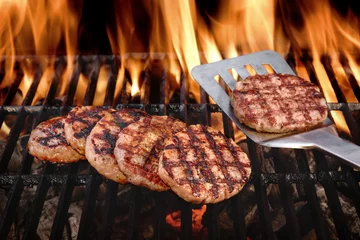 Crédence de cuisine en verre imprimé Grill / Barbecue Beef Burgers On The Hot Flaming BBQ Charcoal Grill