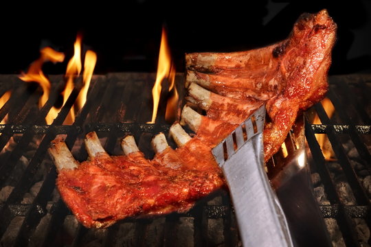 Pork Spare Ribs Barbecuing On The Flaming Charcoal Grill