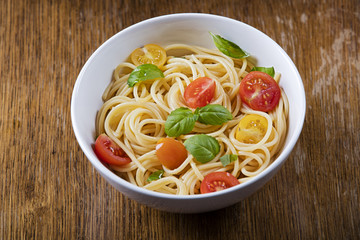 Delicious pasta in bowl on wooden background 