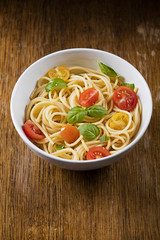 Delicious pasta in bowl on wooden background 