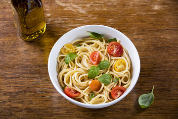 Delicious paste and olive oil bottle on wooden background