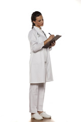 young woman doctor in uniform with clipboard on a white background