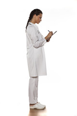 young woman doctor in uniform with clipboard on a white background