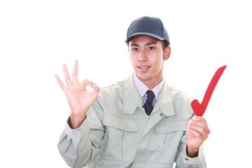 レ点のマークを持つ笑顔の作業員