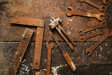 Old rusty wrench on dirty wooden table