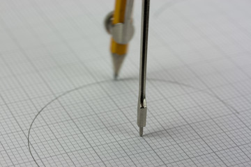 Close up of a compass on graph paper