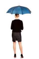 Back view of business woman holding an umbrella