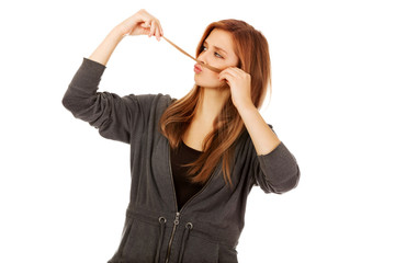 Teenage woman making moustache from hair