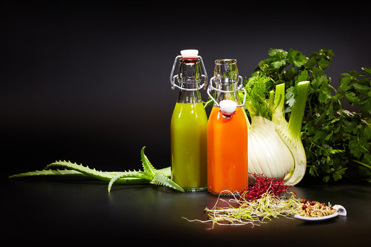 Bottles with fresh vegetable juices isolated on black. Detox die