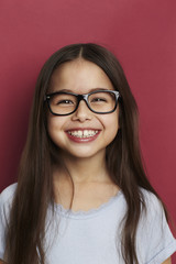 Obraz premium Smiling girl in front of red background, smiling