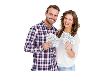 Happy young couple holding fanned out currency notes