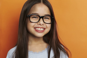 Smiling girl on orange background, portrait