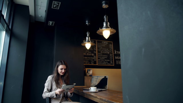 Beautiful hipster woman using laptop at cafe