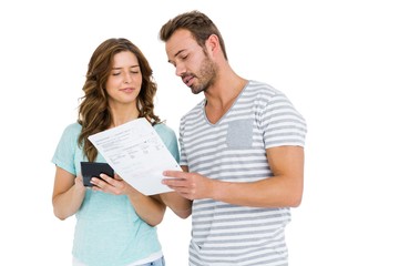 Worried couple calculating bill on calculator