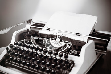 Old typewriter on wooden table. Vintage style tinted photo.
