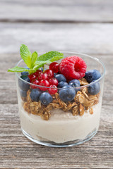 dessert with milk cream, muesli and berries, vertical