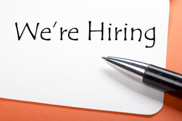 We are hiring. Office desk table with notepad, pen. Top view. 