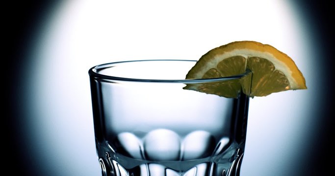 Wasser flie&szlig;t in Glas mit Zitrone Zeitlupe
