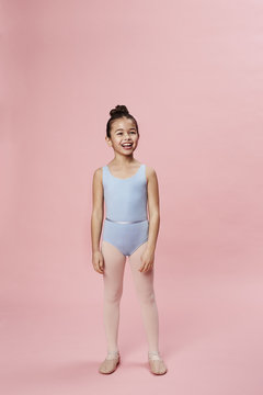 Ballet girl laughing in pink studio