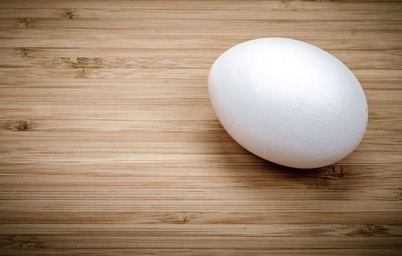 White one Egg on a wooden surface clous up