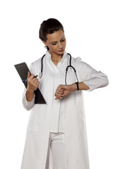 beautiful woman doctor in uniform looking at her watch