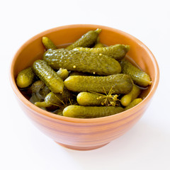 Pickled cucumbers gherkins in ceramic cup on a white background