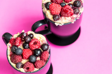 Mug Cakes with Berries Prepared in Microwave on Pink Funny Background, Horizontal View, Top View, Close-up