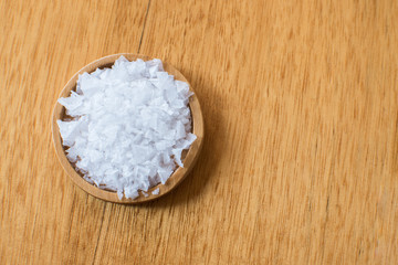 Obraz na płótnie Canvas Sea salt heap crystal on the wooden table.