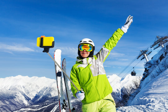 Happy skier woman take selfie with phone on stick