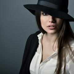 Young beautiful sexy woman in jacket, white shirt and hat over g