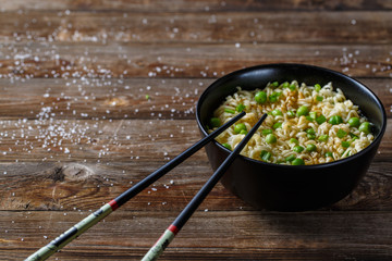 Bowl of noodles with fresh peas and chopped onion.