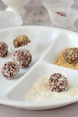 Fototapeta na wymiar Homemade chocolate truffles with walnuts, almonds and coconut