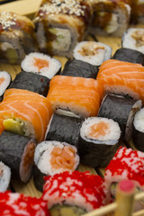 Sushi set with different fish on a wooden plate.