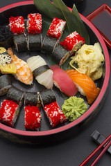 Sushi set with ginger wasabi and chopsticks and soy saue over stone background