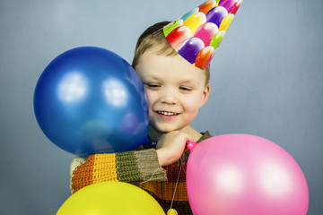Fototapeta na wymiar boy in a celebratory cap with colored balls