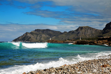 Majorca, Colonia de Sant Pere, view shore and tower with mountains in the background