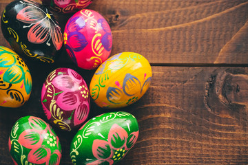 Beautiful painted colorful Easter eggs on old brown wooden background