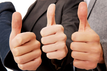 Three business people showing thumbs up