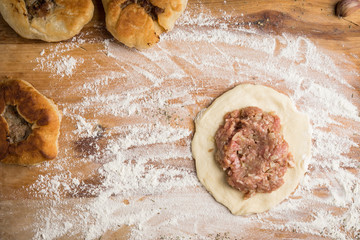 Homemade meat pies on the wooden background