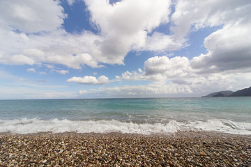 Beautiful sea paradise beach on a background of blue sky with clouds.
