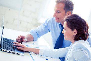 man and woman working with laptop in office
