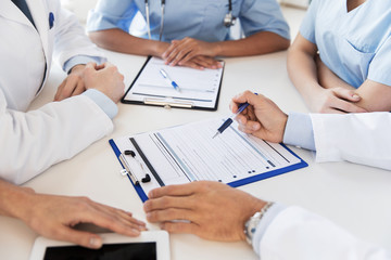 close up of doctors with clipboards at hospital