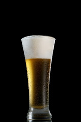 Glass of beer on black background