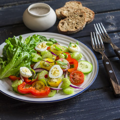 Fresh salad with cherry tomatoes, cucumbers, sweet peppers, celery and quail eggs. Healthy tasty food
